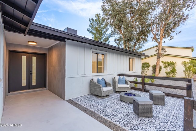 view of patio with french doors and an outdoor living space with a fire pit