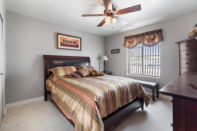 bedroom featuring light carpet, ceiling fan, and baseboards