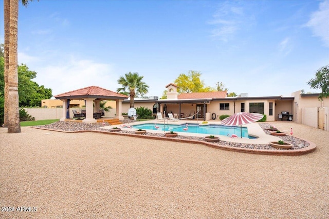 pool featuring fence, a patio, and a gazebo