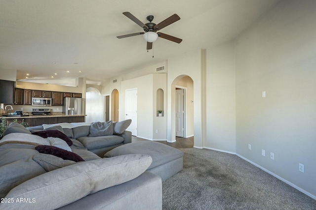 living room featuring sink, vaulted ceiling, ceiling fan, and carpet flooring