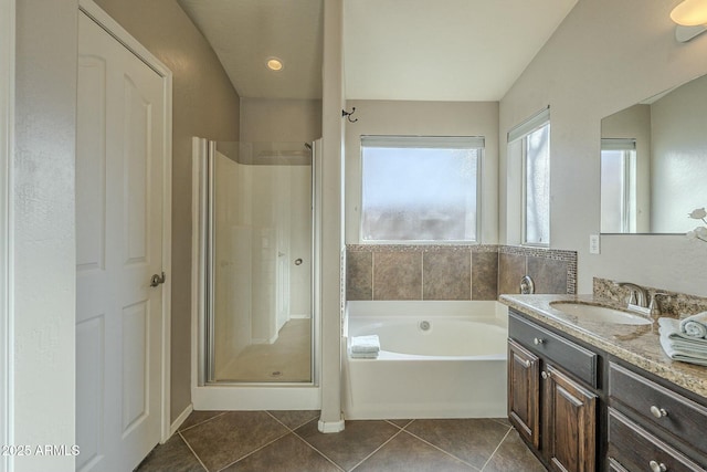 bathroom featuring plus walk in shower, tile patterned floors, and vanity