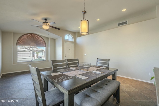 dining space with dark tile patterned flooring and ceiling fan