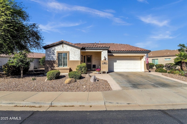mediterranean / spanish-style home featuring concrete driveway, stucco siding, a tiled roof, and an attached garage