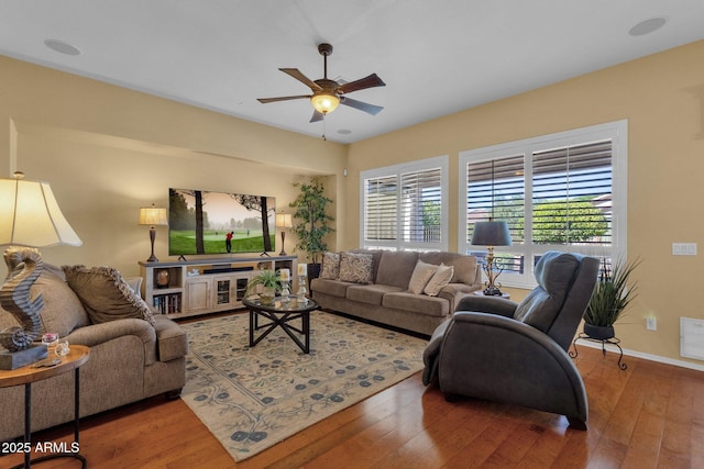 living room featuring hardwood / wood-style floors, baseboards, and a ceiling fan