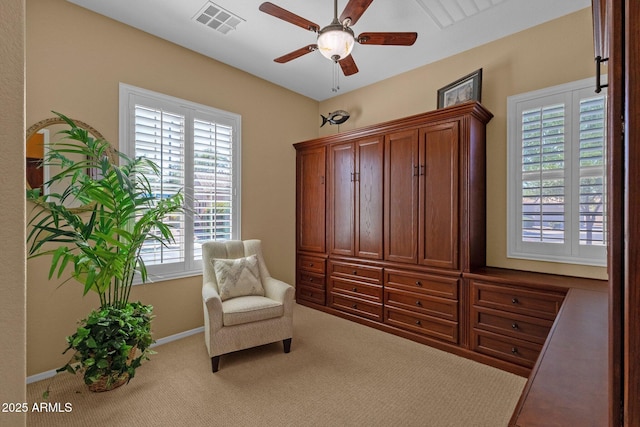 living area featuring baseboards, visible vents, ceiling fan, and carpet