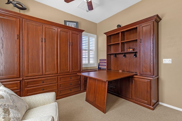 home office with lofted ceiling, a ceiling fan, baseboards, and light carpet