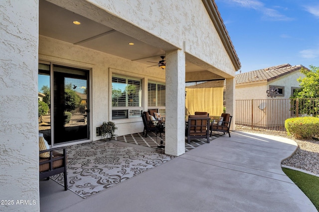 view of patio with outdoor lounge area, fence, and ceiling fan