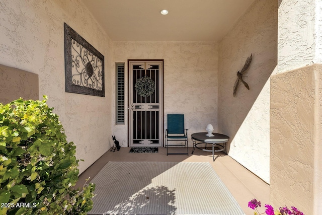 doorway to property featuring a patio and stucco siding