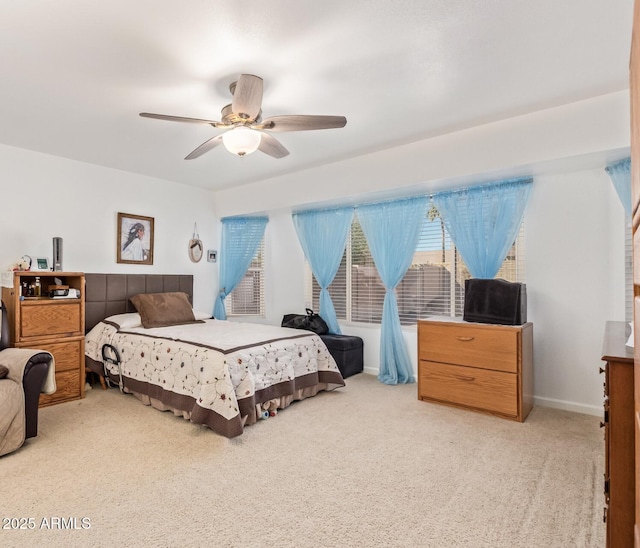 bedroom featuring light carpet, baseboards, and a ceiling fan