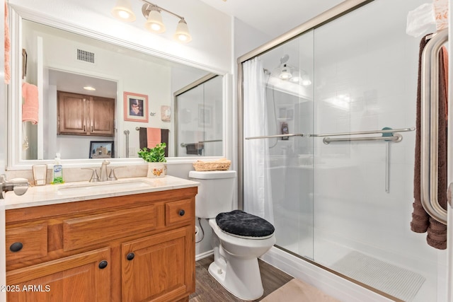 full bathroom featuring toilet, a shower stall, visible vents, and vanity