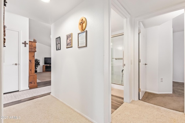 hall featuring carpet flooring and baseboards