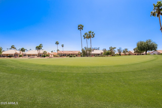 view of community featuring view of golf course and a lawn