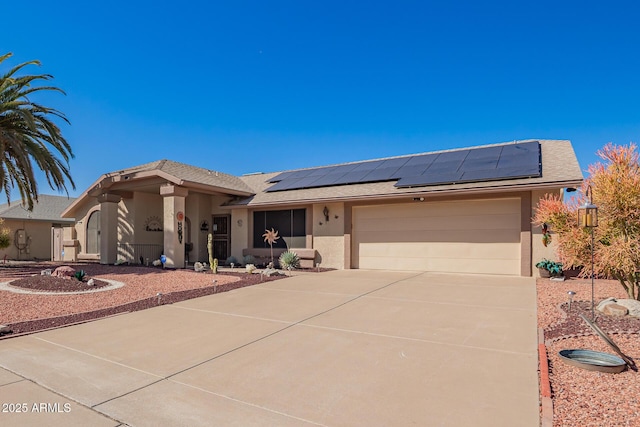 view of front of property with a garage, driveway, solar panels, and stucco siding