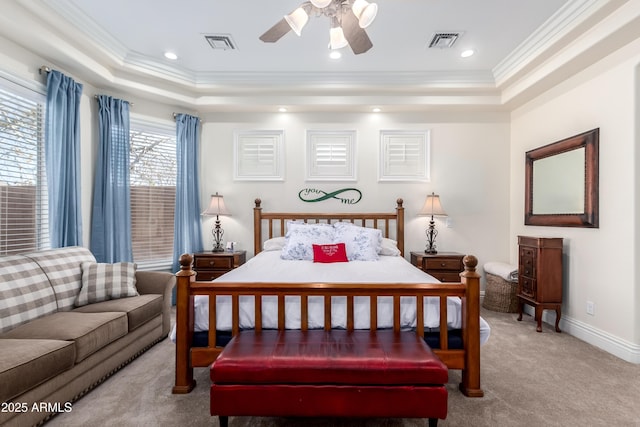 carpeted bedroom with crown molding, ceiling fan, and a raised ceiling