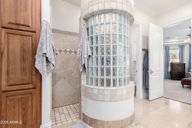 bathroom with a tile shower, ornamental molding, and ceiling fan