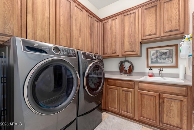 clothes washing area with cabinets, separate washer and dryer, and sink