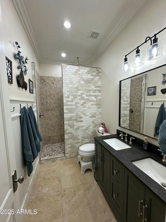 bathroom featuring vanity, crown molding, toilet, and tiled shower