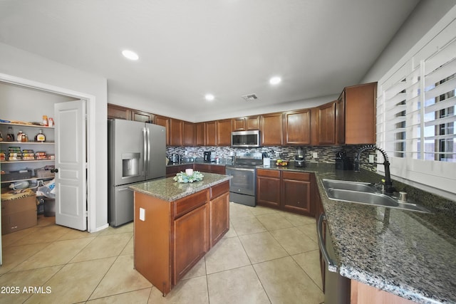 9719 W Heber Rd, Tolleson, AZ 85353 - kitchen featuring a kitchen island, appliances with stainless steel finishes, tasteful backsplash, a sink, and dark stone countertops