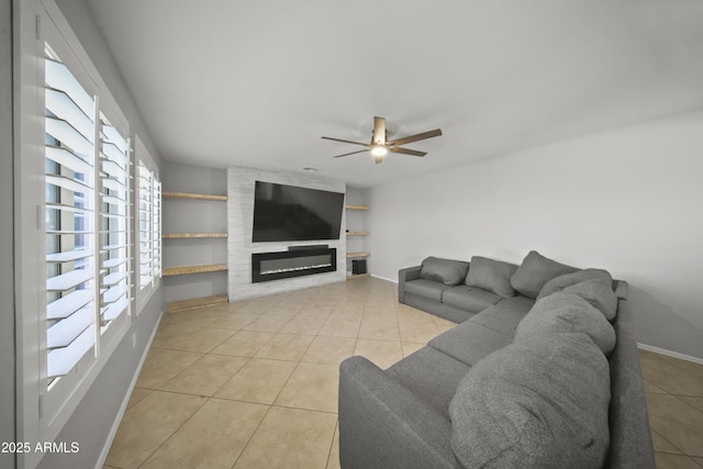 9719 W Heber Rd, Tolleson, AZ 85353 - living room featuring light tile patterned flooring, a ceiling fan, a glass covered fireplace, and baseboards