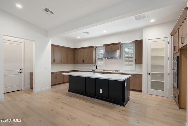 kitchen featuring light countertops, appliances with stainless steel finishes, visible vents, and under cabinet range hood