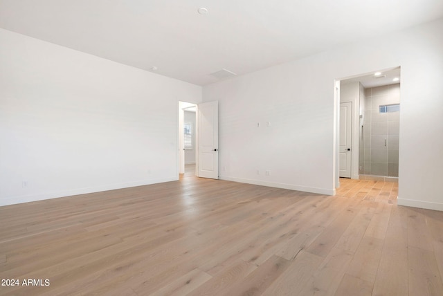 unfurnished room with light wood-style flooring and baseboards