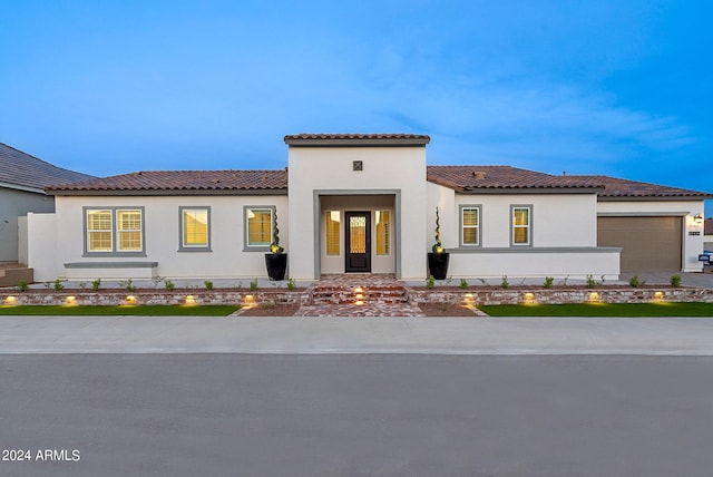 mediterranean / spanish-style home with a tiled roof and stucco siding