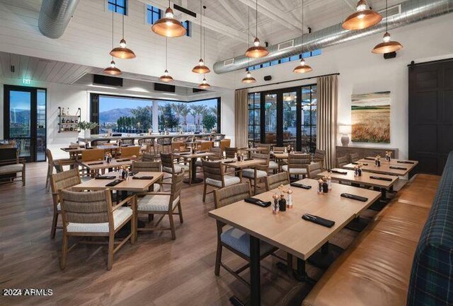 dining area featuring french doors, wood finished floors, and a towering ceiling