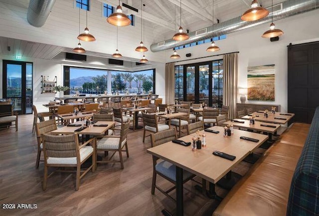 dining area featuring french doors, a towering ceiling, and wood finished floors