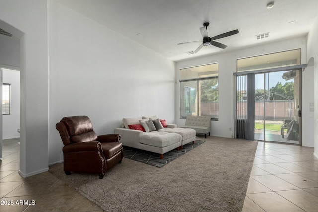 living area featuring light tile patterned floors, visible vents, and a ceiling fan