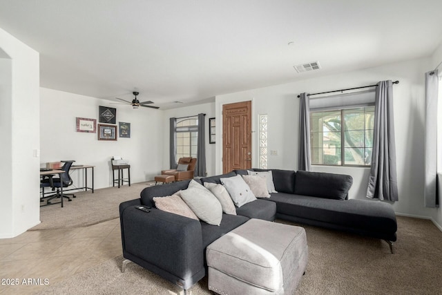 living area with light carpet, light tile patterned floors, visible vents, and a ceiling fan