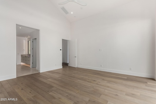 6970 E Joshua Tree Ln, Paradise Valley, AZ 85253 - empty room with light wood-type flooring, baseboards, high vaulted ceiling, and ceiling fan