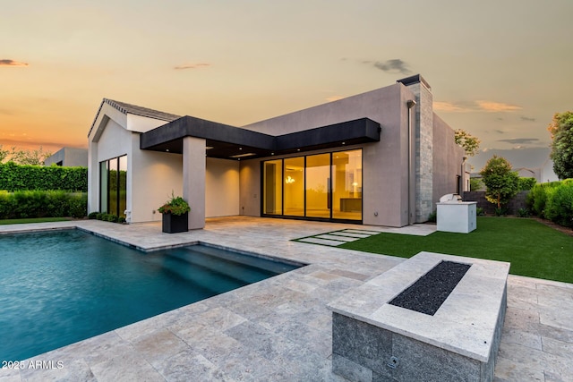 6970 E Joshua Tree Ln, Paradise Valley, AZ 85253 - back of property with a patio area, an outdoor pool, a yard, and stucco siding