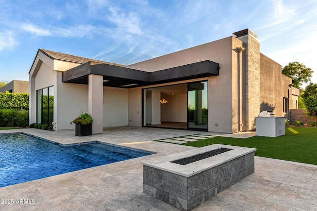 6970 E Joshua Tree Ln, Paradise Valley, AZ 85253 - back of property featuring an outdoor fire pit, a patio area, an outdoor pool, and stucco siding