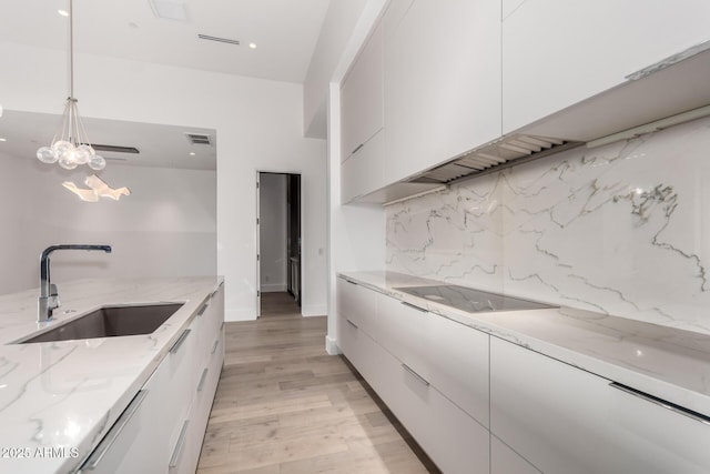 6970 E Joshua Tree Ln, Paradise Valley, AZ 85253 - kitchen featuring a sink, modern cabinets, black electric stovetop, white cabinetry, and recessed lighting