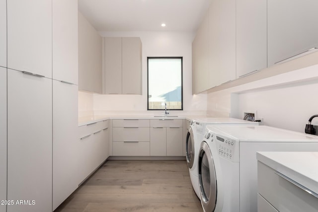 6970 E Joshua Tree Ln, Paradise Valley, AZ 85253 - washroom featuring cabinet space, light wood-style floors, separate washer and dryer, and recessed lighting