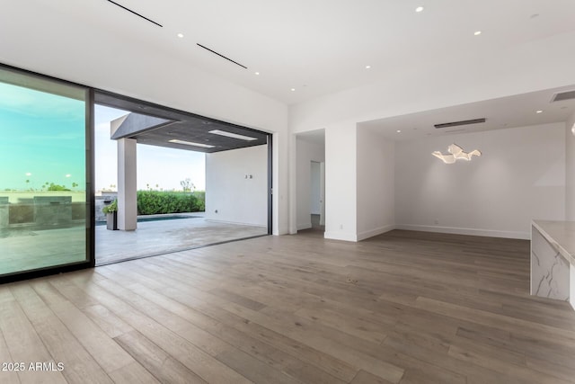 6970 E Joshua Tree Ln, Paradise Valley, AZ 85253 - empty room featuring wood finished floors, baseboards, recessed lighting, and a wall of windows