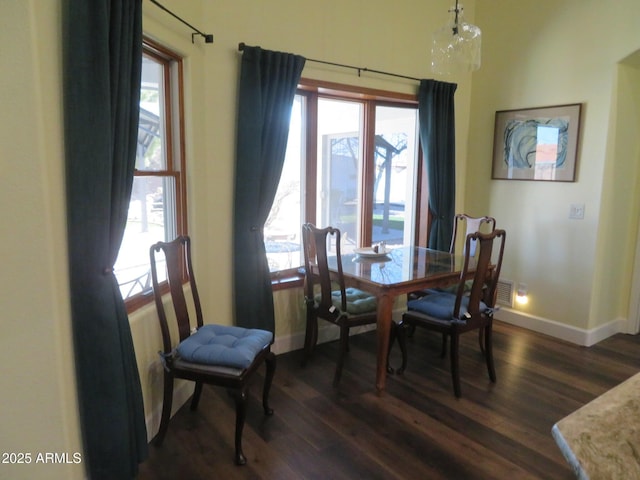 dining area with baseboards and dark wood finished floors