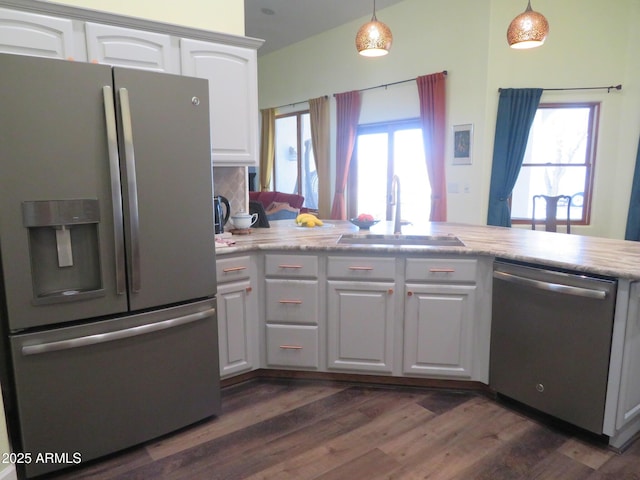 kitchen featuring stainless steel appliances, a wealth of natural light, white cabinetry, and a sink