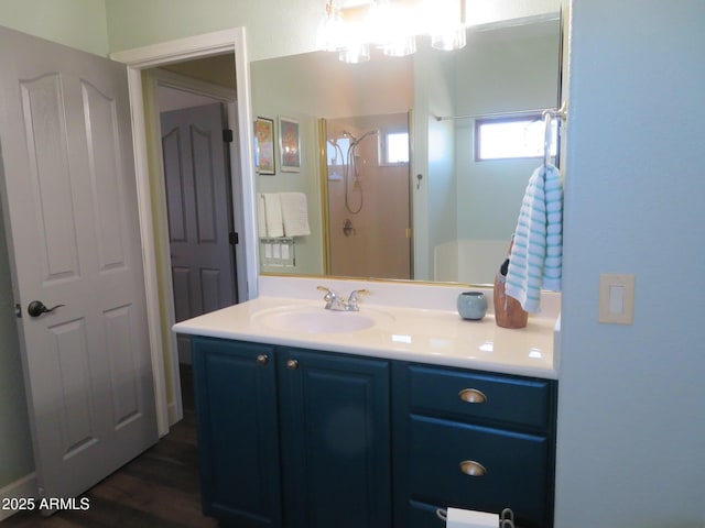 bathroom featuring a shower, wood finished floors, and vanity