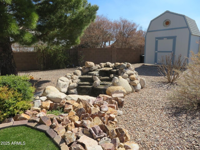 view of yard featuring a fenced backyard, an outdoor structure, and a shed