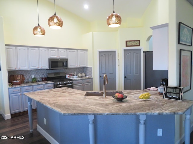 kitchen featuring a peninsula, appliances with stainless steel finishes, a breakfast bar, and a sink