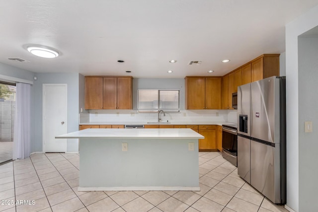 kitchen with decorative backsplash, sink, a kitchen island, and stainless steel appliances