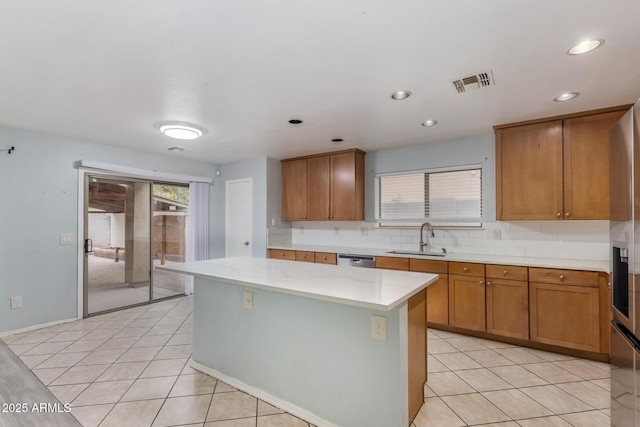 kitchen featuring stainless steel dishwasher, a kitchen island, light tile patterned floors, and sink