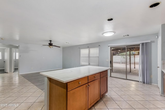 kitchen featuring a center island, ceiling fan, and light tile patterned flooring