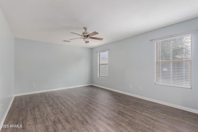 spare room featuring ceiling fan and dark wood-type flooring