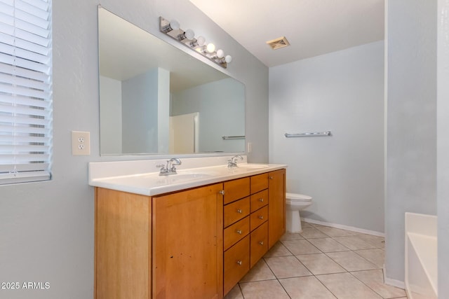 bathroom with tile patterned flooring, vanity, toilet, and a tub