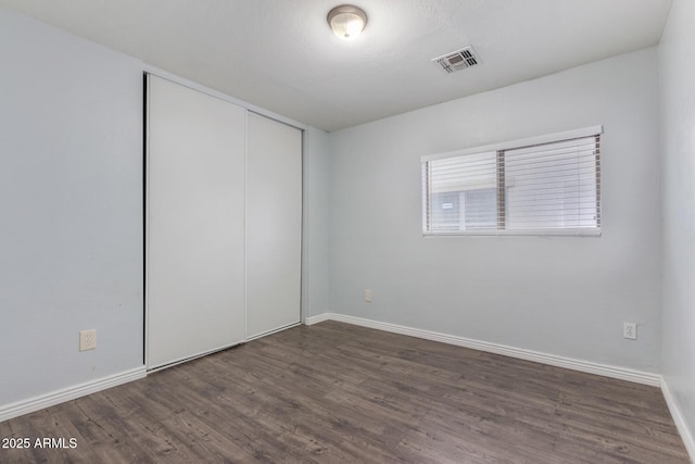 empty room with dark hardwood / wood-style flooring