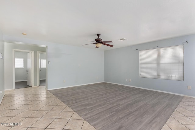 empty room featuring light tile patterned floors and ceiling fan