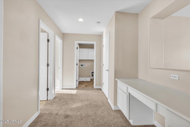 hallway featuring light colored carpet