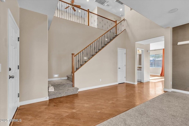 foyer entrance featuring a towering ceiling and hardwood / wood-style floors